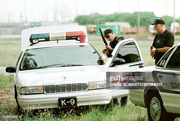Miami Springs Sargent Randy Walker , a member of a K-9 police unit, handles a shotgun as he joins others in a search 17 July for serial killer Andrew...