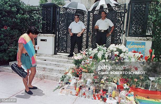 Beach goer stops to read and look at notes and flower arrangements left by wellwishers on the steps of the house of slain Italian designer Gianni...