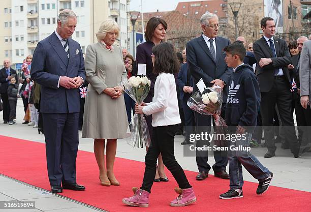 Prince Charles, Prince of Wales, and Camilla, Duchess of Cornwall, receive flowers from children that the royal couple laid at a memorial to people...