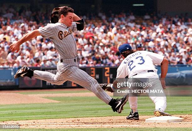 Pittsburgh Pirates player Jason Kendall tries but fails to reach first base safely as Los Angeles Dodgers first baseman Eric Karros fields the ball...