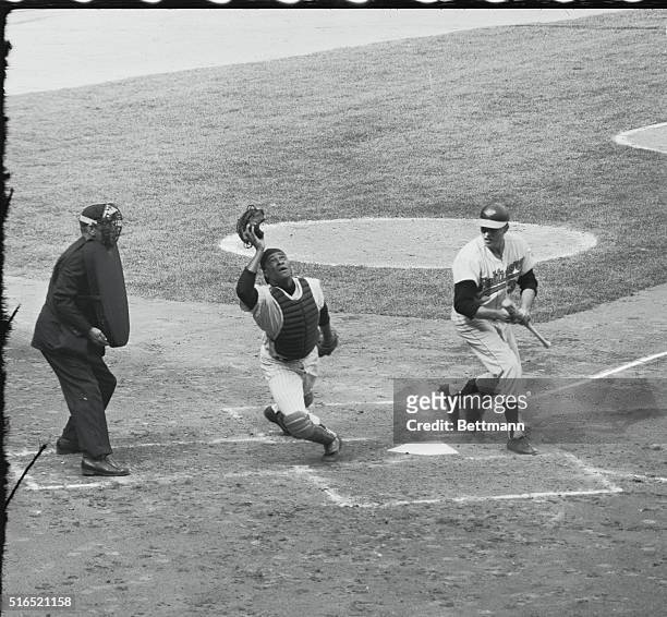 Bronx, New York: Yankees vs. Orioles. Orioles' Pappas, attempting to bunt in third frame, fouls one off, as Howard starts after ball in Stadium...