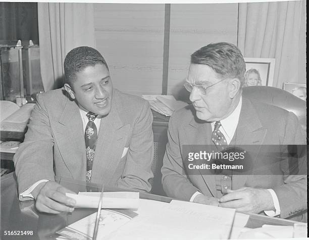 Photo shows Don Newcombe talking to Branch Rickey before signing his 1950 contract at the Dodger office.