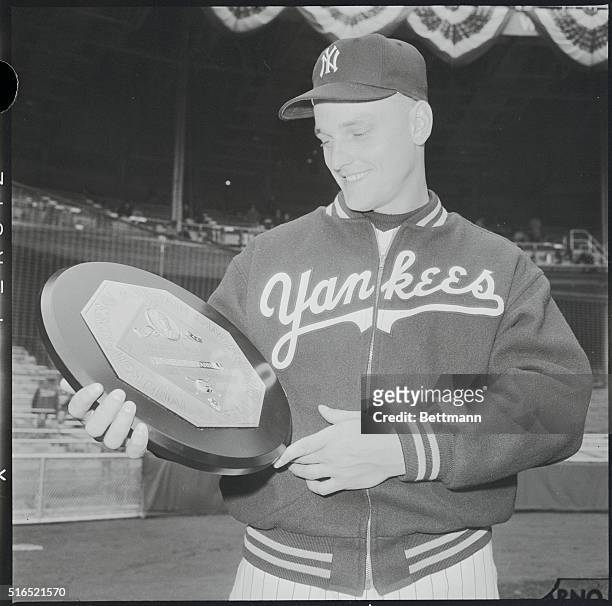 New York Yankees' champion home run hitter, Roger Maris, looking at his award, the Most Valuable Player plaque, prior to game on April 11 the season...