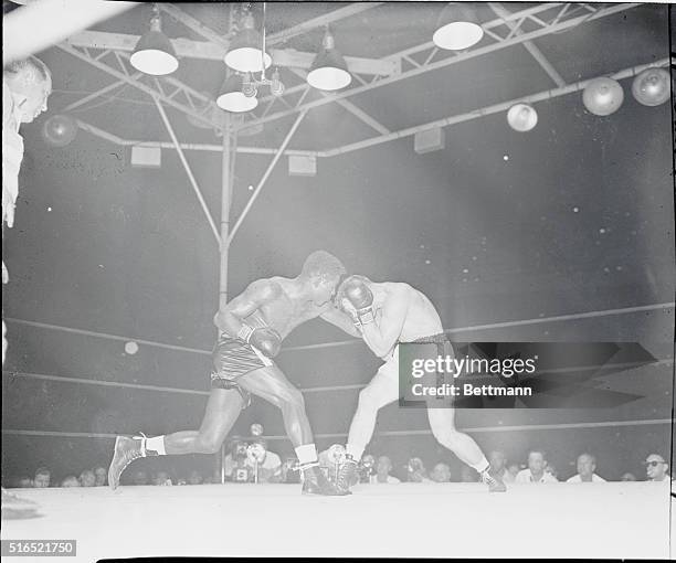 Gus Lesnevich receives a stomach punch from Ezzard Charles in the late rounds of a fight in August 1949.