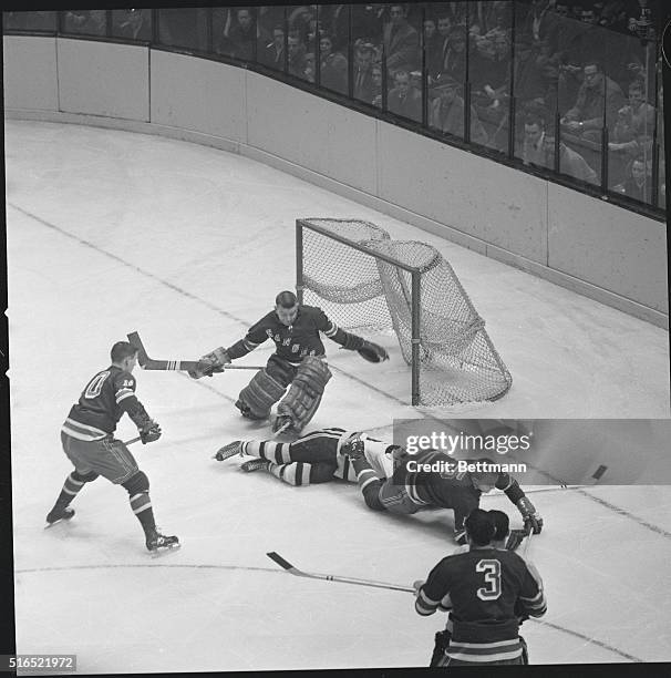 Ranger goalie Gump Worsley makes sweeping save on Murray Oliver's shot as Blues' defense man Don Johns rides Boston forward out of play. Howell...