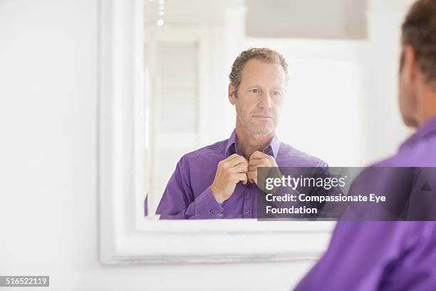 businessman examining himself in mirror - purple shirt stock-fotos und bilder