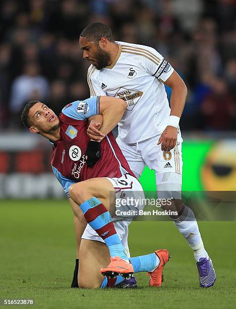 Rudy Gestede of Aston Villa and Ashley Williams of Swansea City face off during the Barclays Premier League match between Swansea City and Aston...