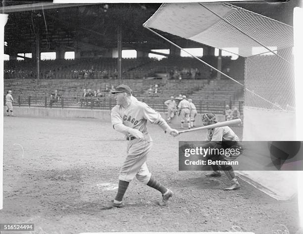 Rogers Hornsby is shown at the finish of his swing during batting practice at the spring training camp of the Chicago Cubs.