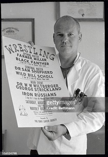 Dr.Samuel Sheppard holds up a poster announcing his debut in professional wrestling, to be held August 9. The match will be held in Waverly, Ohio,...