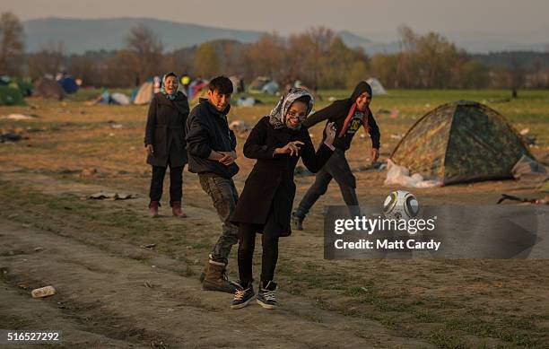 People play football at the Idomeni refugee camp on the Greek Macedonia border on March 19, 2016 in Idomeni, Greece. Thousands of migrants remain...