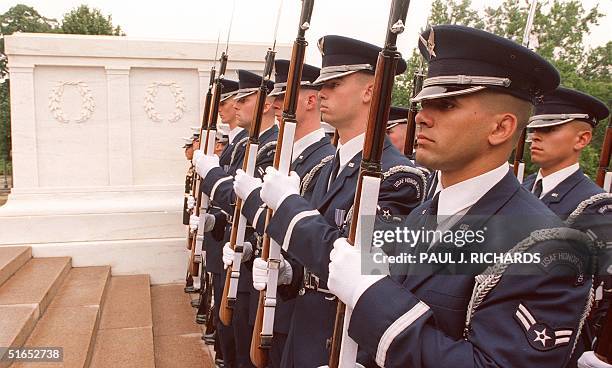 Members of the US Air Force Honor Guard stand at attention at Arlington National Cemetery at the Tomb of the Unknown Soldier during Memorial Day...