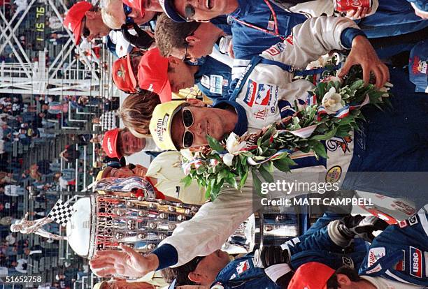 Arie Luyendyk of Holland wave to the crowd from the winners circle 27 May after winning the 81st Indianapolis 500 automobile race at Indianapolis,...