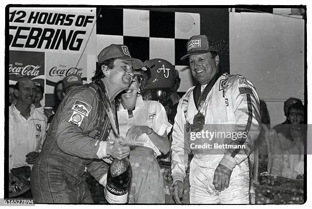 Bob Wolleck sprays champagne as he and co-driver A.J. Foyt celebrate in victory lane after winning the 12-hour Sebring endurance race with an average...