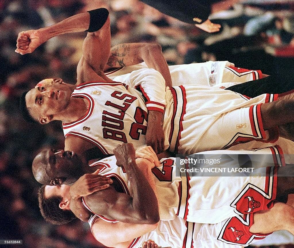 Scottie Pippen (R) of the Chicago Bulls hugs teamm