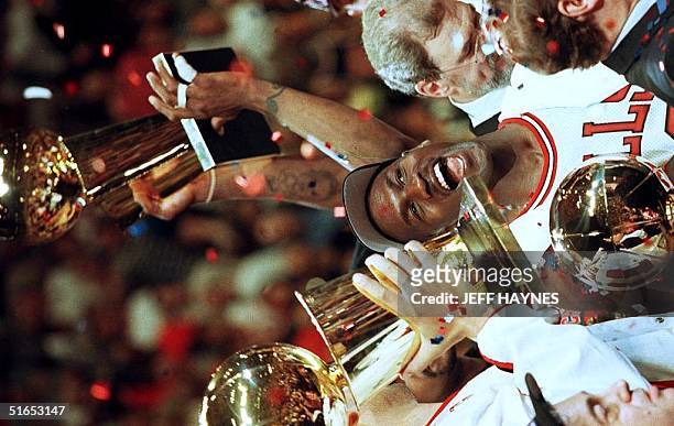 Chicago Bulls player Michael Jordan is surrounded by NBA Championship trophies after his team defeated the Utah Jazz 90-86 to win the 1997 NBA Finals...