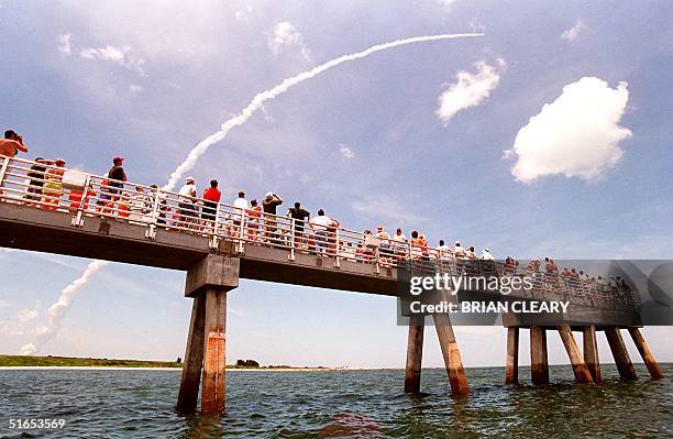 Residents of the Cape Canaveral area stand at Jetty park in central Florida and look up at the smoke trail left by the Space Shuttle Columbia 01 July...