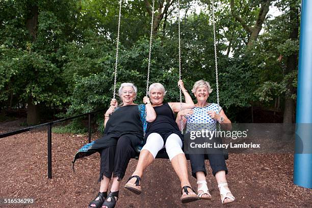 senior girlfriends enjoying themselves on a swing - ung i själen bildbanksfoton och bilder