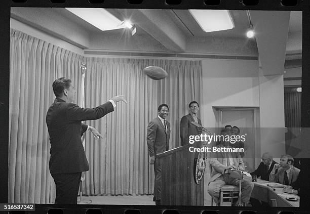 Sacramento: Gov. Ronald Reagan uncorks a perfect press conference pass to "Speedy" Duncan , of the San Diego Chargers, as Clem Daniels , San...