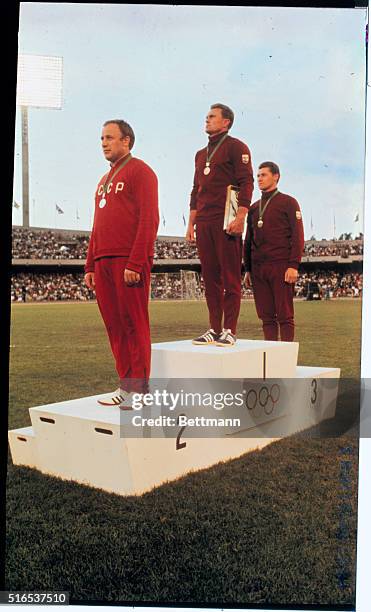Mexico City: Winners in the Oct. 17th Hammer Throw event, with their medals. First place Gyula Zsivotzky of Hungary, second place Romuald Klim of...