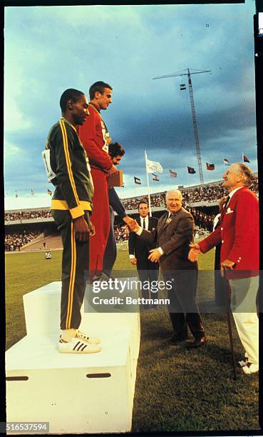 Mexico City: Giuseppe Gentile of Italy gets congratulations after receiving his Bronze medal in the Triple Jump event of the 1968 Olympics. First...
