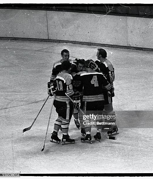 Boston Bruins' Bobby Orr and Phil Esposito embrace each other as they are surrounded by fellow teammates after Orr broke his own record for points...