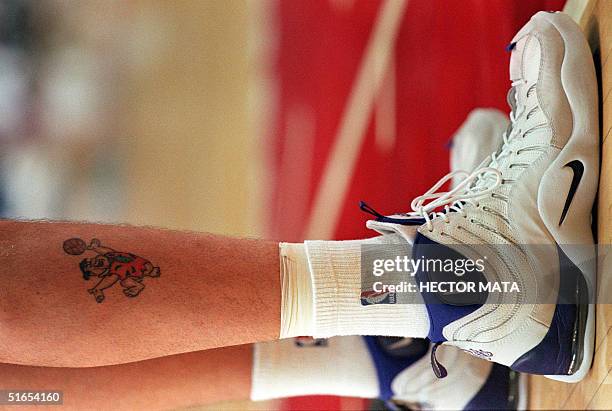 Utah Jazz player Greg Ostertag, who sports a tattoo of the cartoon character "Fred Flintstone" handling a basketball, stands near the basket during...