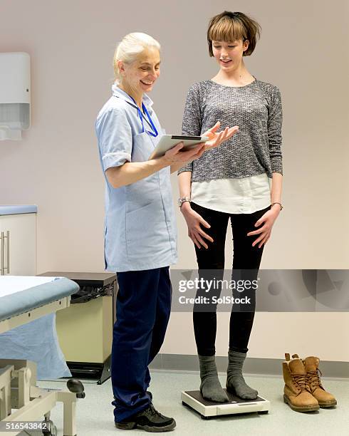 nurse weighing teenager girl - balancing scale stock pictures, royalty-free photos & images