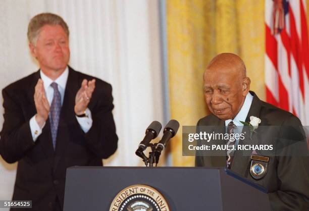 Ninety-four-year-old Herman Shaw speaks as US President Bill Clinton looks on during ceremonies at the White House in Washington 16 May in which...
