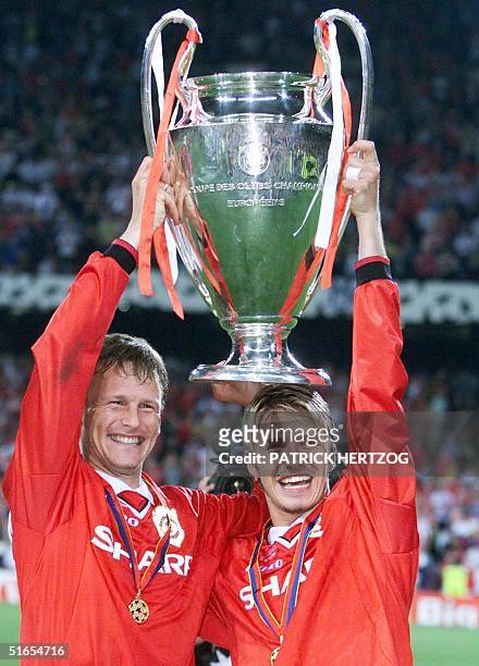 Midfielders of Manchester United, Teddy Sheringham and David Beckham hold aloft the Cup, after winning the final of the soccer Champions League...