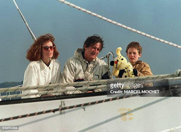 Skipper Olivier de Kersauson, accompanied by his wife Caroline and their son Arthur, poses for photographers after his arrival into the Brest harbor...