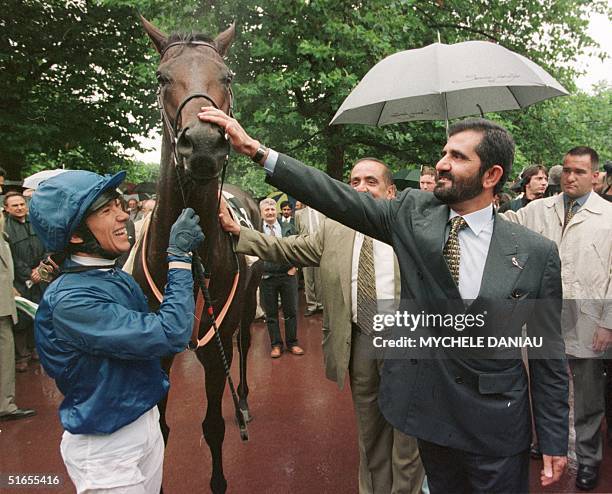 Race horse owner Sheikh Mohamed Al Maktoum , pets his horse Dubai millenium next to Italian jockey Franco Dettori after following their victory in...
