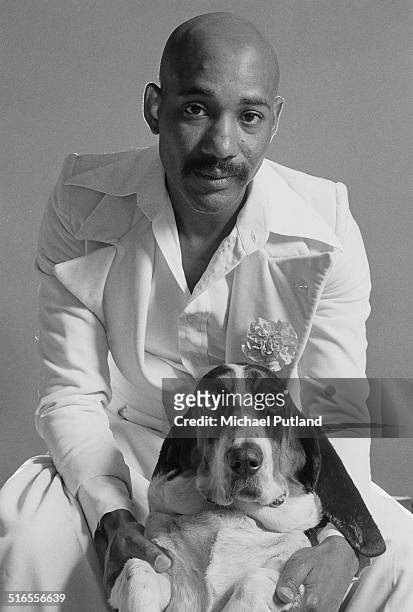 Singer-songwriter Errol Brown, of British pop group Hot Chocolate, posing with a basset hound, April 1974.