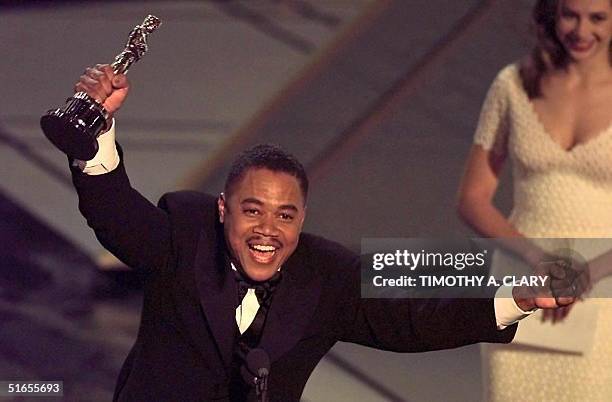 Actor Cuba Gooding, Jr holds up his Oscar after winning the Best Supporting Actor Award for his role in "Jerry Maguire" during the 69th Academy...