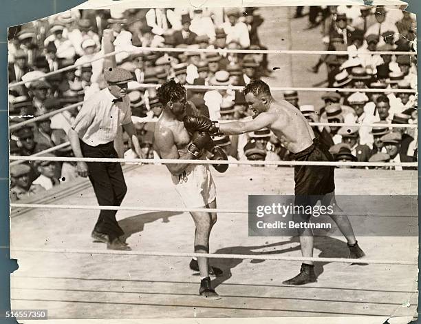 Tom Gibbons, the St. Paul heavyweight, lands a left swing to Dempsey's body in the 11th round, one of the three rounds which the contender was...