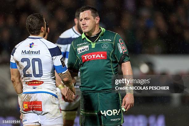 Pau's flanker James Coughlan shakes hand with Castres' fullback Julien Caminati after wining the French Top 14 union rugby match between Pau and...