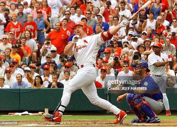 Mark McGwire of the St. Louis Cardinals follows through on his swing after hitting his 61st homerun against Chicago Cub's Mike Morgan at Busch...