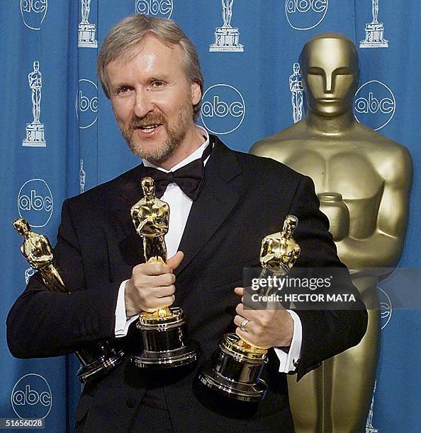 James Cameron holds the three Oscars he won for Best Fim, Best Director, and Best Editing 23 March at the 70th Annual Academy Awards at the Shrine...