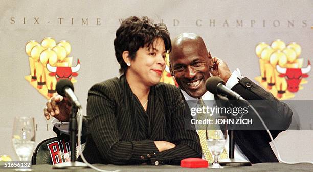 Michael Jordan of the Chicago Bulls laughs as his wife Juanita is questioned by reporters about how her life will change with Michael Jordan's...