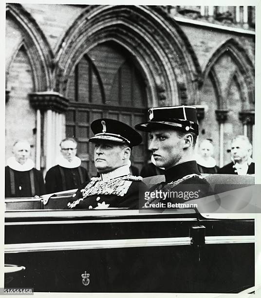 Solemn Occasion. Trondheim, Norway: Wearing serious expressions, King Olav V of Norway and his son, Crown Prince Harald, leave in the royal car,...