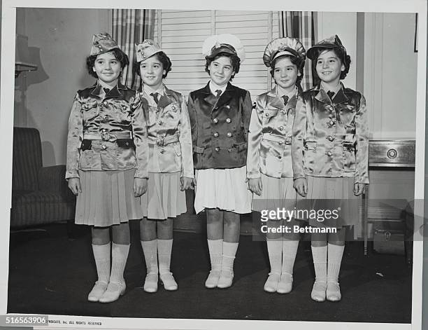Showing Off The Quints Winter Wardrobe. The patriotic note is added to the winter wardbrode of the Dionne Quintuplets by uniforms patterned after...