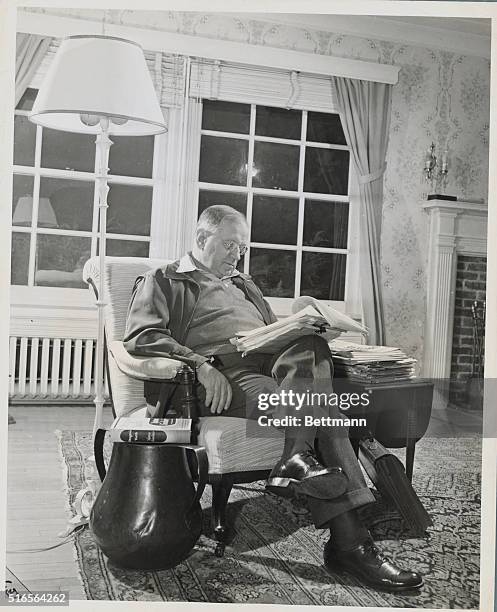 Harold L. Ickes reading some reports in his home at Olney, Maryland which really is a large farm. As Secretary of the Interior, he was responsible...