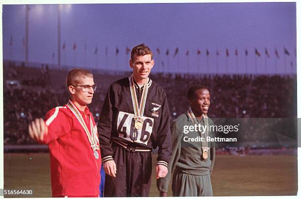 Tokyo, Japan: Medal winners of the 800m run at the Tokyo Olympics. Bill Crothers watches as gold medal winner Peter Snell shakes hands with third...