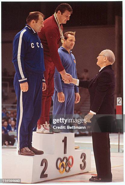 Tokyo, Japan: Olympic wrestler Eilfried Dietrich stand at far right as Hungarian Istvan Kozma gets gold medal for fight place in the Greco-Roman...