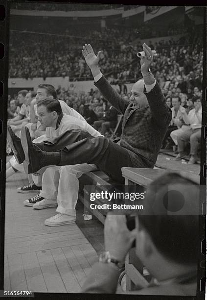 Celtics' coach Auerbach is a happy man as he relishes every Celtics' basket in final moment of game . Trainer Buddy Leroux watches game as Tommy...