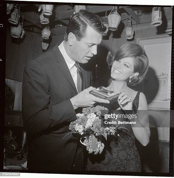 Actor Rock Hudson examines Itlay's most coveted acting award the Silver Ribbon as he congratulates his co-star, Italian actress Claudia Cardinale who...