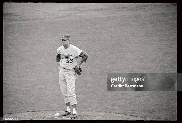 Dodger's pitcher Don Drysdale, stands on mound, disgusted with himself as he watched Willie McCovey congratulate Willie Mays , after the latter...