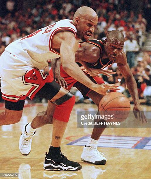 Mookie Blaylock of the Atlanta Hawks reaches in and steals the ball from Ron Harper of the Chicago Bulls 08 May during the second half of game two of...