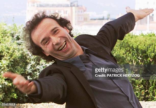 Italian director Roberto Benigni gestures as he poses for photographers at a photocall for his film "La Vita e Bella", 17 May at the Palais des...