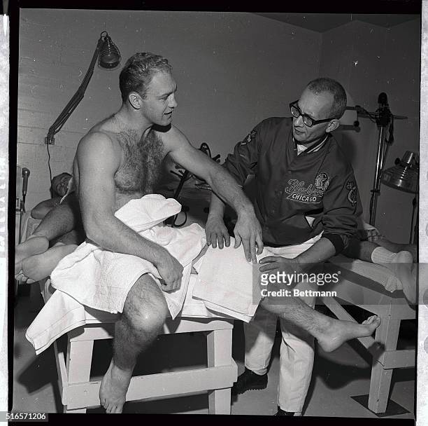 Black Hawk trainer Nick Garen puts hot packs on knee of Chicago Black Hawks' Bobby Hull, who twisted his knee in the game 11/21 against Toronto....