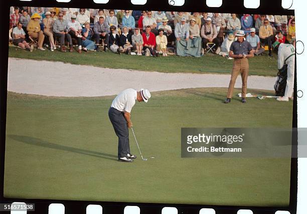 Jack Nicklaus putts out on 18th hole as Don January looks on. Nicklaus finished this third round of play in the Masters Golf Tournament, in a first...